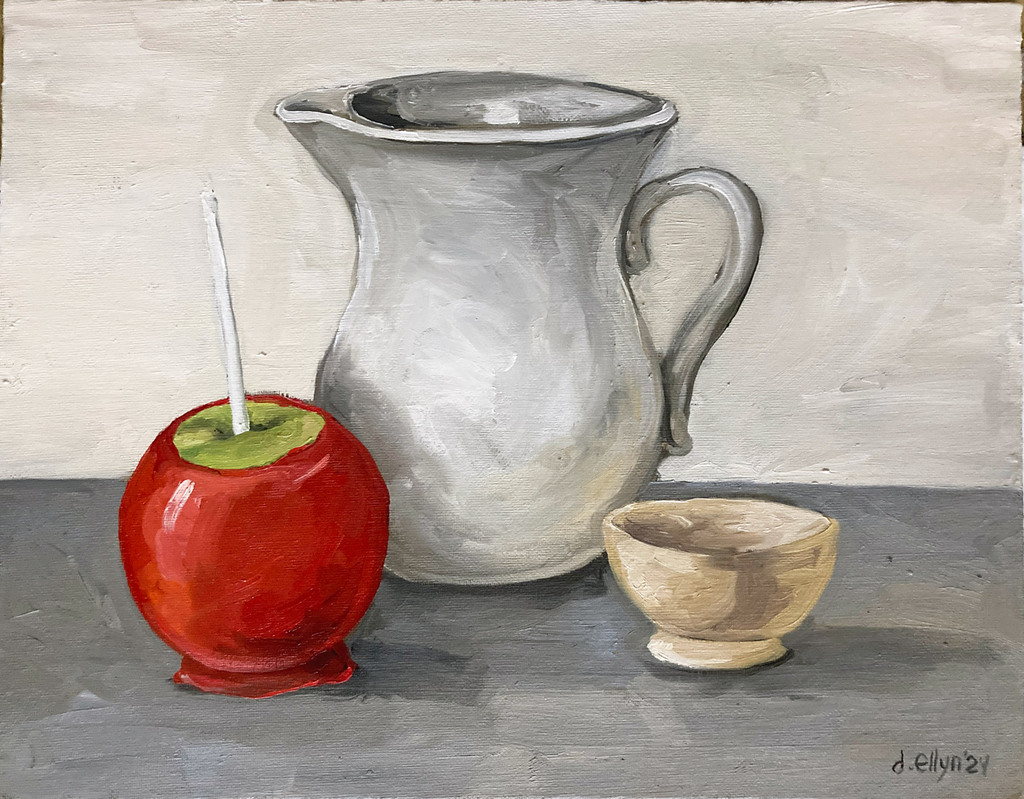 Still life with glossy red candy apple, white ceramic pitcher, and small neutral-toned bowl on gray tabletop.